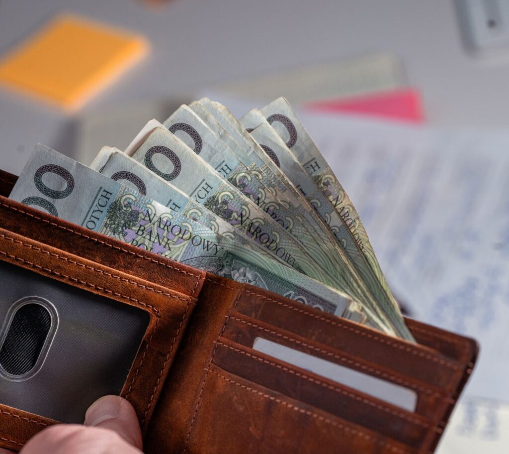 Portfel z banknotami i dokumenty rozliczeniowe na biurku